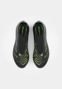 Zwarte sportschoenen met een gladde textuur en groene accentlijnen. Lage snit met een ronde neus en een gevoerde binnenkant.