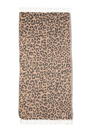 Beżowa prostokątna tkanina z czarnym wzorem w cętki lamparta i białymi frędzlami na obu krótszych krawędziach.