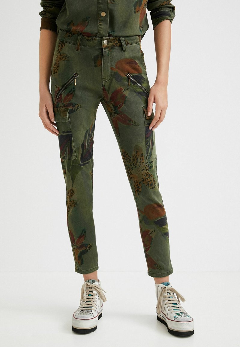 Gröna blommönstrade cargobyxor med fickor med dragkedja, slim fit och av bomullsmaterial. Försedda med detaljer i leopardtryck.