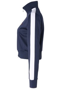Marineblauwe ritsjack met verticale ribbeltextuur, hoge kraag, witte schouderstrepen en strakke manchetten. Bevat een logo op de linkerborst.