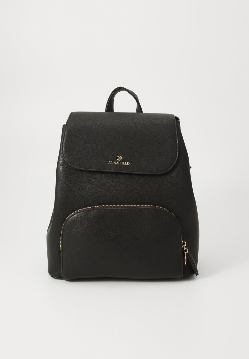 Zaino in pelle nera con tasca frontale con zip, bordi arrotondati e chiusura a patta. Presente il logo dorato e dettagli hardware.