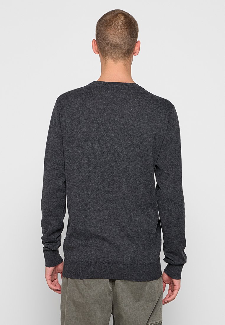 Pull en maille gris foncé, col rond, manches longues, poignets ajustés, ourlet côtelé, texture lisse, avec un motif subtil.