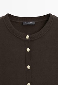 Dark brown ribbed shirt with round neckline and four decorative gold buttons down the front, made by Massimo Dutti.