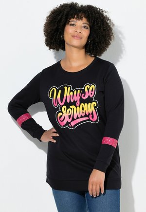 Schwarzer Sweatshirt mit einem großen "Warum so ernst?"-Grafik in Pink und Gelb. Mit glitzernden pinken Akzenten an den Ärmeln. Lässige Passform.