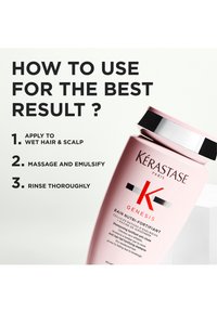 Rosa sjampoflaske med svart og sølvfarget kork, med merkevaren "Kérastase" og "Genesis", bruksanvisning synlig.