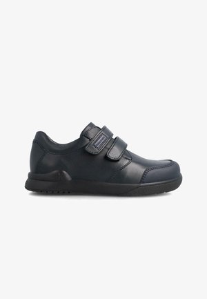 Zapatillas de velcro negras con parte superior de cuero suave, punta redondeada, cuello acolchado y suela de goma texturizada. Diseño minimalista sin patrones.