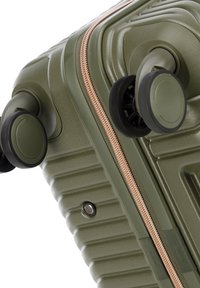 Valigia rigida verde oliva con texture rigata, zip dorata rosa e doppie ruote per la mobilità. Dotata di una chiusura sicura e una finitura liscia.
