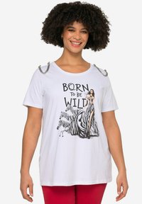 Hvid t-shirt med korte ærmer, prydet med et grafisk design af en catwalk-model og zebraer, sølvfarvede skulderdetaljer og fed tekst, der siger "BORN TO BE WILD."