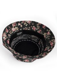 Cappello a secchiello con motivo floreale su sfondo nero, caratterizzato da rose rosa e foglie verdi. L'interno è in tessuto nero con branding.