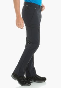 Men's navy outdoor pants made of stretchy fabric, featuring zippered pockets, reinforced seams, and a tapered fit for mobility.