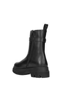 Schwarze Leder-Ankle-Boots mit seitlichem Reißverschluss, robuster Sohle und einer Schlaufe für einfaches Anziehen. Glatte Textur mit minimalistischem Design.