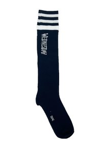 Calcetines de color azul marino hasta la rodilla con rayas blancas y el texto "MIÉRCOLES" tejido en el lateral; hechos de una tela elástica y suave.