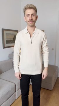 Beige ribbed knit pullover with a zip collar, long sleeves, and a slim fit; paired with black pants against a light background.