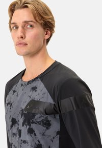 Grå og svart idretts skjorte med tie-dye mønster, mesh-detaljer og en slank, moderne passform. Logoen er plassert på brystområdet.