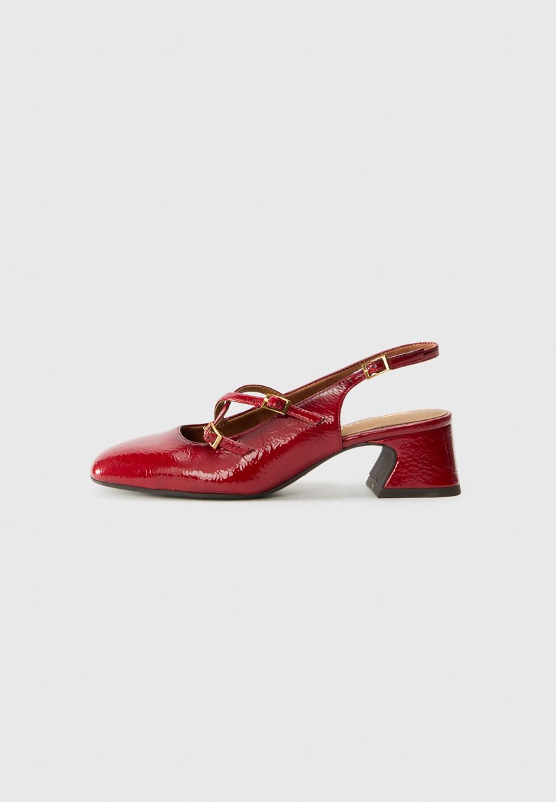 Chaussure slingback en cuir verni rouge avec un nez pointu, un petit talon carré et des accents de boucle dorée sur la sangle. Texture lisse et brillante.