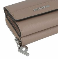 Portefeuille texturé beige avec fermeture éclaire argentée et accessoires de marque, présentant une finition lisse et un design compact.