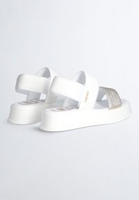 Sandali platform bianchi con due fasce larghe, una in materiale bianco e l'altra in metallo texturizzato, con una soletta marchiata.
