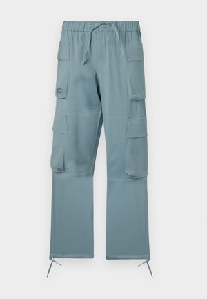 Helle blaue Cargo-Hose mit elastischem Bund, verstellbarem Kordelzug, mehreren Seitentaschen und Bindebändern an den Knöcheln. Glatte Stofftextur.