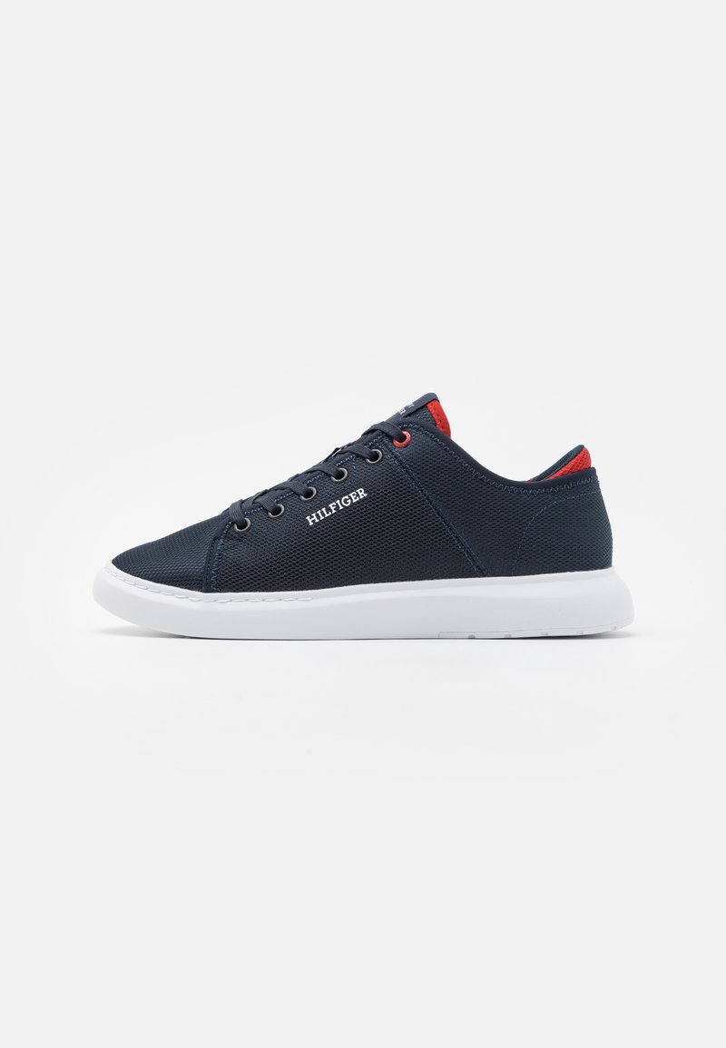 Navyblaue Mesh-Sneaker mit weißer Gummisohle, runder Zehenpartie und kontrastierenden roten Akzenten an der Ferse und Zunge. "HILFIGER"-Logo an der Seite.