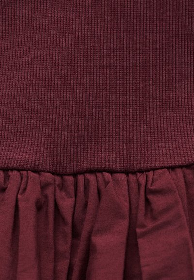 Rochie burgundy cu secțiune superioară cu dungi și tier inferior liber, adunat, realizat dintr-un material moale, texturat.