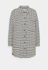 Svart och vit rutig skjorta jacka med långa ärmar, knappstängning och avslappnad passform. Tillverkad av ett texturerat tyg.
