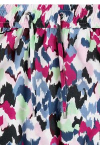 Taille à cordon avec embouts métalliques sur un tissu présentant un motif abstrait multicolore en rose, bleu, vert, noir et blanc.