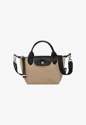 Beige Tasche mit schwarzen Lederakzenten, doppelten Handgriffen, verstellbarem Schulterriemen und einer strukturierten Klappe. Verfügt über silberne Beschläge und dekorative Quasten.