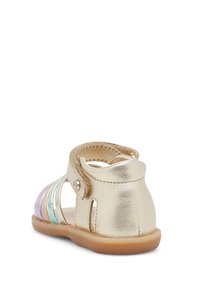 Zlaté kovové sandály s multibarevnými průhlednými pruhy. Mají zaoblenou špičku, zadní pás a strukturální podrážku pro dobrou přilnavost. Nastavitelný střih.