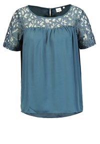 Teal bluse med kortærmet blonde, rund halsudskæring og løs pasform. Har en nøglehulslukning bagpå, blødt stof og teksturerede blonder.