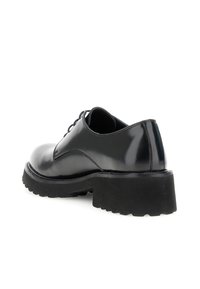 Scarpa in pelle nera lucida con lacci, suola spessa con tasselli e tacco basso, inclinata per mostrare la vista laterale e posteriore su sfondo bianco.