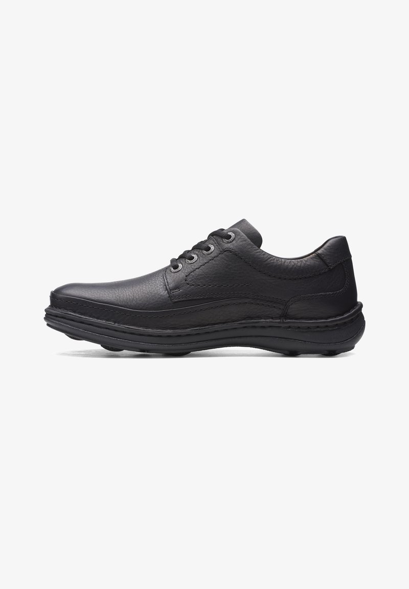 Black leather shoes with a textured finish, low-profile design, rounded toe, and five eyelet lace-up closure. Durable rubber sole.