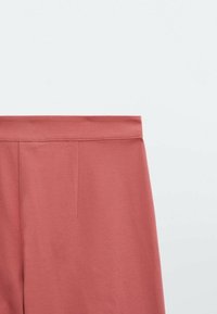 Roze gekleurde broeken met een gladde textuur, een brede tailleband en een plooidetail aan de voorkant. De stof lijkt zacht en rekbaar te zijn.