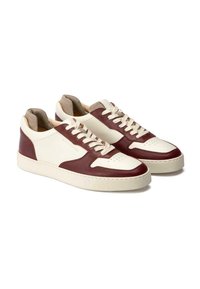 Leder-Sneaker in einem weiß-burgunderfarbenen Farbschema, mit strukturierten Oberflächen, perforierter Zehenpartie und cremefarbenen Schnürsenkeln.