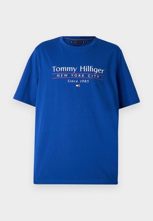Niebieska bawełniana koszulka z krótkimi rękawami. Zawiera napis "Tommy Hilfiger Nowy Jork od 1985" w białym i czerwonym kolorze oraz detal z logo.