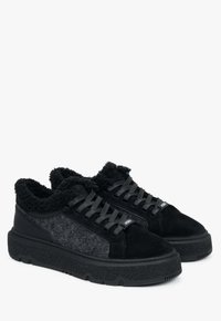 Baskets noires avec un panneau latéral en laine texturée, un col moelleux et une semelle en caoutchouc épaisse avec un motif de traction prononcé.