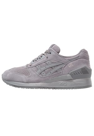 Baskets ASICS en daim gris clair avec lacets, bout perforé et semelle texturée, vues de côté sur fond blanc.
