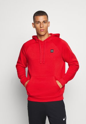 Red hooded sweatshirt with a kangaroo pocket and a small black logo on the chest. Made from soft fabric with raglan sleeves.
