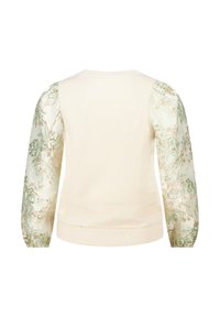 Sweatshirt crème avec des manches volumineuses en tissu transparent à motifs dans des tons de vert clair et des accents floraux dorés.