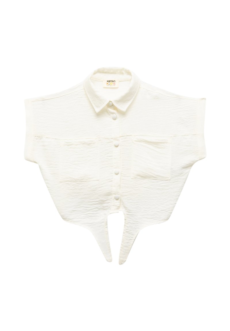 Camicia bianca corta con un tessuto testurizzato, maniche corte, chiusura frontale con bottoni e due tasche sul petto. Presenta un orlo a forma di V.