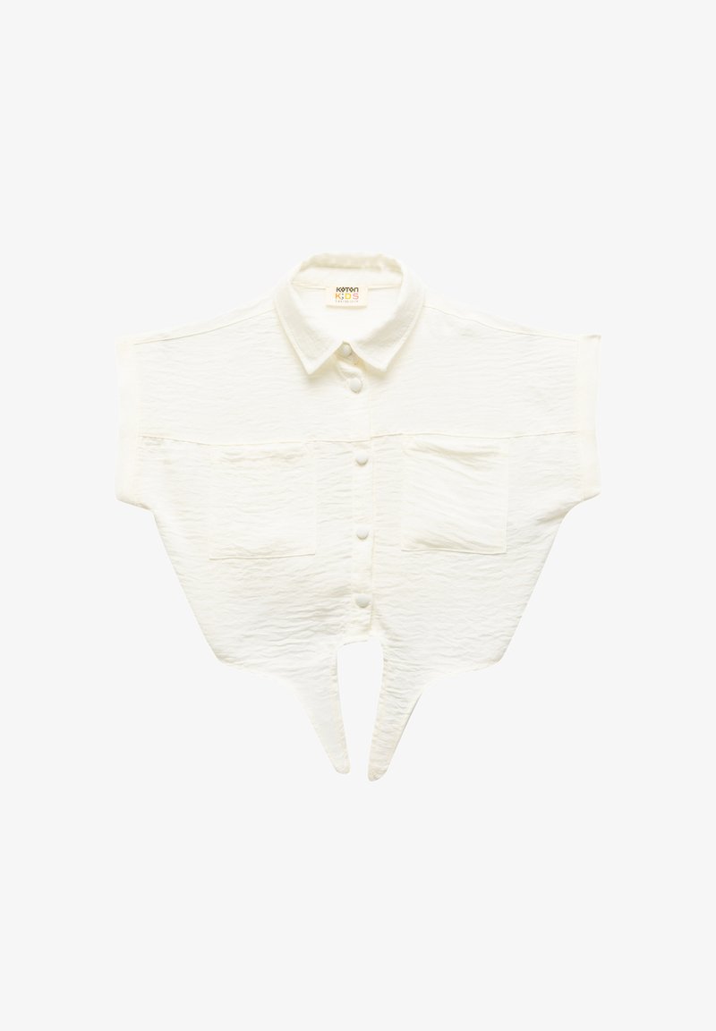 Camisa blanca corta con un tejido texturizado, mangas cortas, cierre de botones al frente y dos bolsillos en el pecho. Presenta un dobladillo en forma de V.