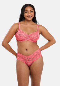 Roze kanten lingerieset met bloemmotieven, geschulpte randen en een zachte textuur. De beha heeft verstelbare bandjes en een haaksluiting.