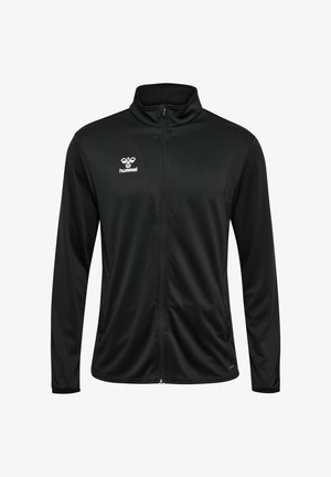 Schwarze Zip-Jacke aus glattem Stoff, mit Stehkragen und dem Hummel-Logo auf der linken Brust. Lange Ärmel und figurbetontes Design.