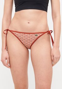 Chilot de baie tip bikini, cu un model geometric în nuanțe de roz și roșu, cu bretele ajustabile și un accent cu un logo mic.