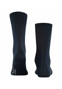 Calcetines azul marino oscuro con textura acanalada. Acabado suave, longitud hasta la mitad de la pantorrilla, puntera y talón reforzados. Logotipo de la marca en la suela.
