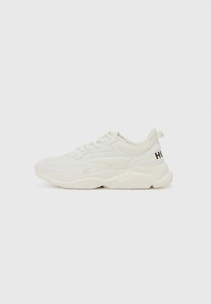 White athletic sneakers with a mix of smooth and textured materials. Features a chunky sole and “HUGO” logo on the heel. Lace-up design.