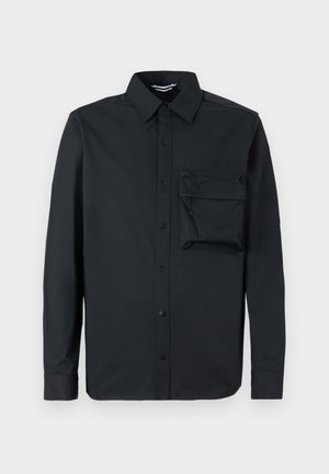 Zwarte langärmige shirt gemaakt van gladde stof. Bevat een button-down kraag en een linkerkastzak met een ritssluiting. Klassieke pasvorm.