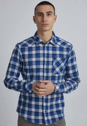 Blå og hvit ruter skjorte med knappelukking, med brystlomme og lange ermer, laget av vevd stoff.