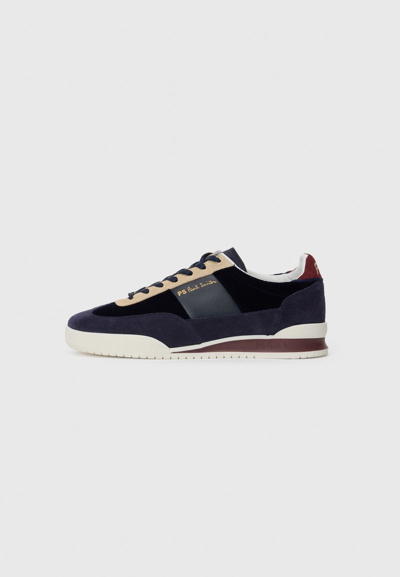 Sneakers in suede blu Navy con accenti beige e blu scuro. Presentano una suola in gomma bianca e un marchio dorato sul lato. Design atletico classico.