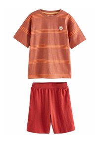 Kortärmad t-shirt i rostfärg med orangea ränder och dödskallelogo, tillsammans med enfärgade röda shorts med elastisk midja.