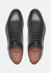 Zwarte leren schoenen met een gladde afwerking, ronde neus en vetersluiting met vijf gaatjes. Binnenkant is van tanleer met een merkl logo.